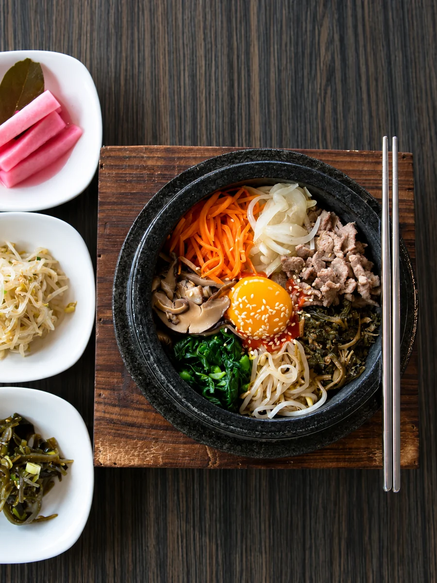 Stone-bowl bibimbap served with Korean side dishes